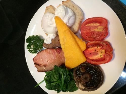 Un plato blanco de comida con carne y verduras. en Gridley Homestead B&B, en Eumundi