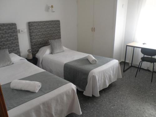 a hotel room with two beds and a table at Hostal Paco Marbella in Marbella