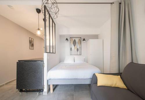 une petite chambre avec un lit et un canapé dans l'établissement ¤Hautiere¤ - plein centre -100m de la plage, à Saint-Brévin-les-Pins