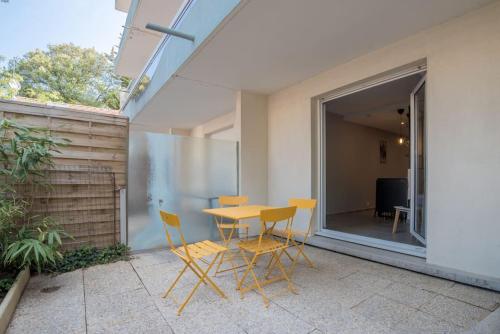 un patio avec une table et des chaises sur un balcon dans l'établissement ¤Hautiere¤ - plein centre -100m de la plage, à Saint-Brévin-les-Pins