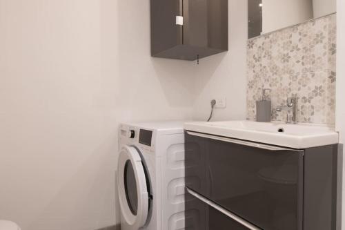 une cuisine avec une machine à laver et un évier dans l'établissement ¤Hautiere¤ - plein centre -100m de la plage, à Saint-Brévin-les-Pins