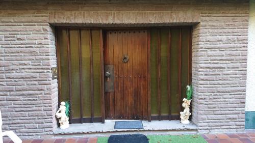 a wooden door with two teddy bears in front of a building at Eifelvilla Urbigkeit in Schönecken