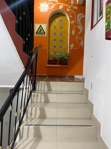 a stairway with white stairs and an orange wall at Gran Hotel Tlaxiaco in Heroica Ciudad de Tlaxiaco