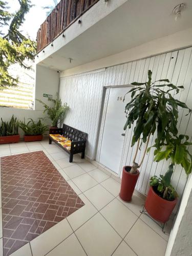 a porch with a bench and plants on a building at Gran Hotel Tlaxiaco in Heroica Ciudad de Tlaxiaco
