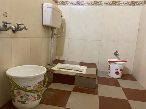 a small bathroom with a toilet and a bucket at Misty Dews (Bharat Builders) in Kodaikānāl