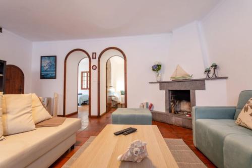 sala de estar con sofá y chimenea en Casa dos Moinhos nearby the beach!, en Porto Formoso