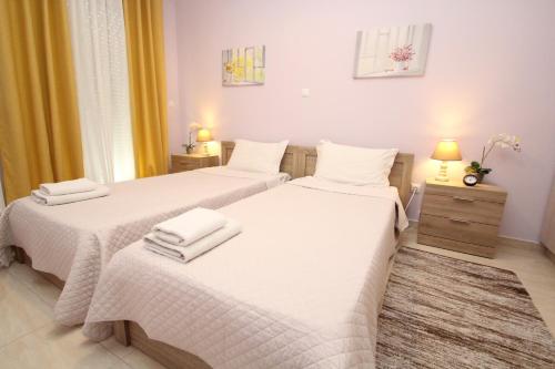 1 dormitorio con 2 camas con sábanas blancas en Filoxenia apartment en Loútsa