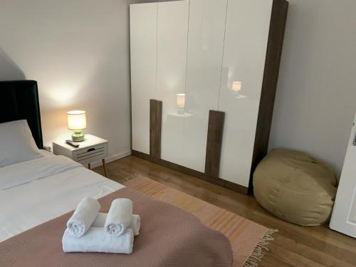 a bedroom with a bed with two towels on it at Iris Apartment in Piatra Neamţ