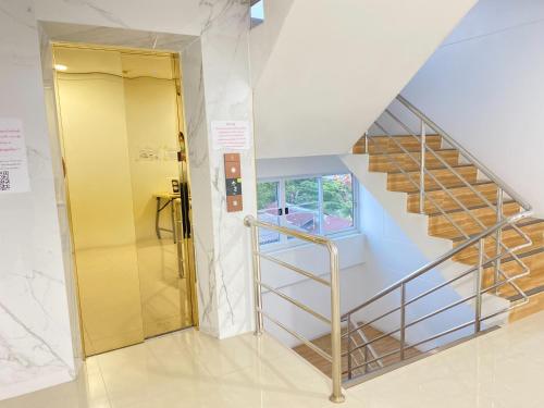 une cage d'escalier avec une porte jaune et une rampe d'escalier dans l'établissement Wellness Mansion Hotel, à Dusit