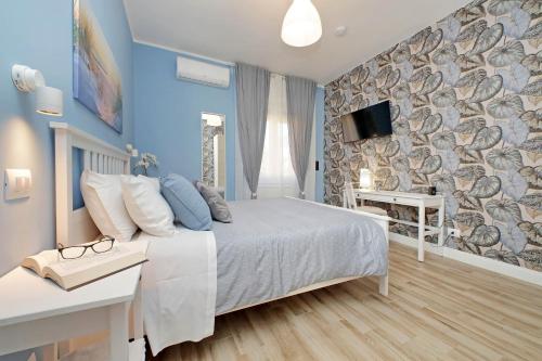 a bedroom with a bed and a tv on a wall at PR APARTMENT - FIUMICINO ROME AIRPORT 9 Min - in Fiumicino
