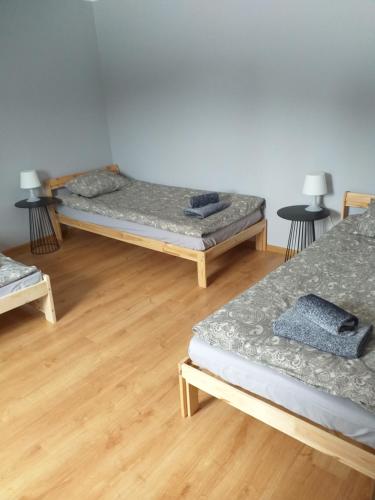 three beds in a room with wooden floors at Kulibaba in Bystrzyca Kłodzka