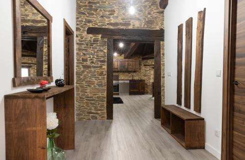 un corridoio aperto con parete in pietra e pavimenti in legno di Casa Rural Lar de Sanxes a Lugo