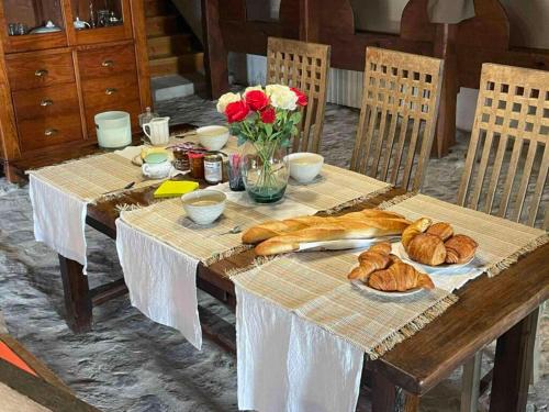 une table en bois avec du pain et des fleurs dessus dans l'établissement Les chambres de Solol, à Félines