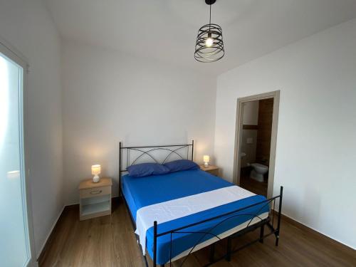 una camera bianca con letto blu di Residence Mariposa a Lido Conchiglia