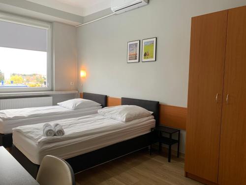 a hotel room with two beds and a window at Premium Hostel & Bistro in Mielec
