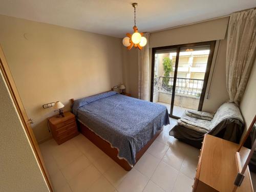 Un dormitorio con una cama azul y una ventana en Playamar Altamar Apartments, en Alcossebre