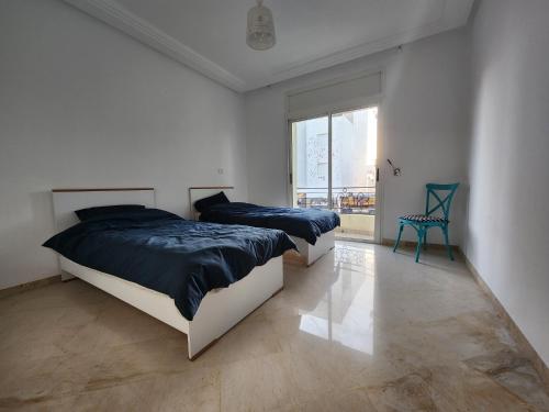 a bedroom with two beds and a large window at Gouletteparadis in La Goulette