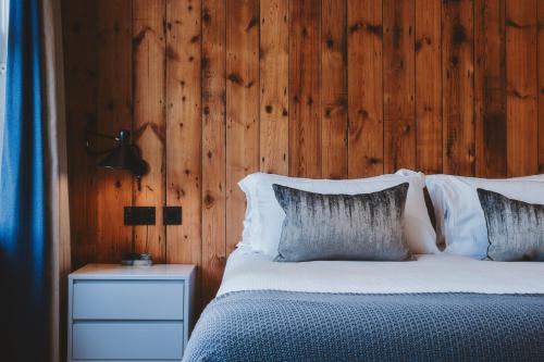 - une chambre avec un lit et un mur en bois dans l'établissement The Brownswood, à Londres