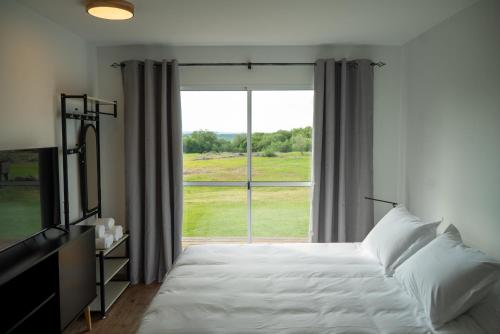 a bedroom with a bed and a large window at VILLA LA BORDONA in Rivera