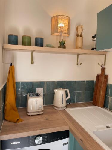 une cuisine avec un comptoir et des appareils électroménagers. dans l'établissement Le Week Riviera III -3 étoiles-Plage du midi-Grande terrasse-Piscine-Cannes- Palais des Festivals, à Cannes