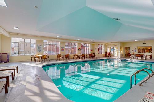 a large swimming pool with tables and chairs at Delton Grand Resort in Wisconsin Dells