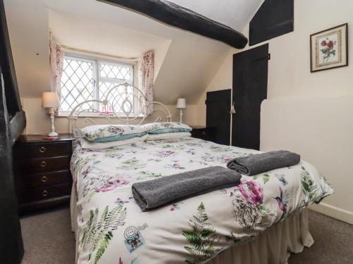 切爾滕納姆的住宿－Mouse Hole Cottage，一间卧室配有一张带两个枕头的床