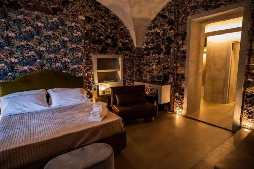 a bedroom with a bed and a chair at CHARME Catania Central Suites in Catania