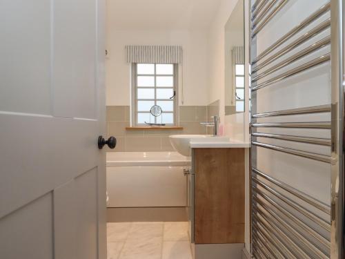 a bathroom with a sink and a refrigerator at Blossom Cottage in Chipping Campden