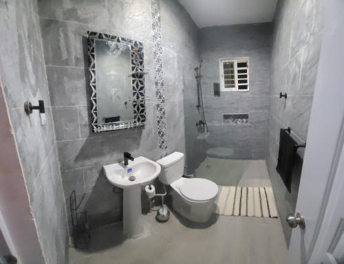 a bathroom with a white toilet and a sink at Rijos tower 3 in Santo Domingo