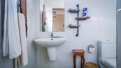 a bathroom with a sink and a mirror and a toilet at Nungwi House in Nungwi