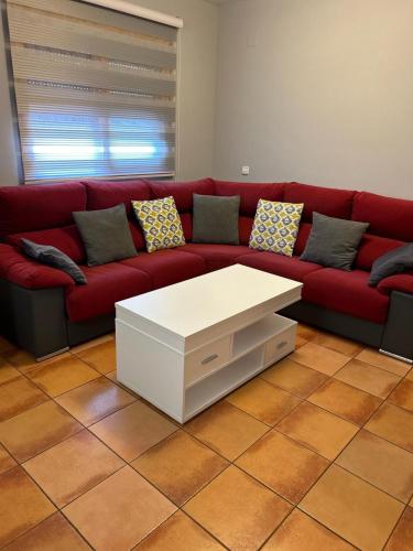- un canapé rouge avec une table basse blanche dans le salon dans l'établissement Casa Lia, à Vejer de la Frontera