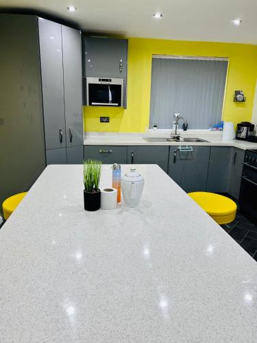 cocina con encimera blanca y paredes amarillas en Room in Oldham, Manchester en Oldham