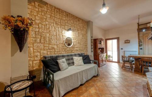een woonkamer met een bed en een stenen muur bij G&S Rustic House in San Pancrazio Salentino