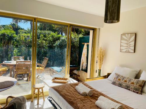 une chambre avec un lit et une grande fenêtre en verre dans l'établissement Le Week Riviera III -3 étoiles-Plage du midi-Grande terrasse-Piscine-Cannes- Palais des Festivals, à Cannes
