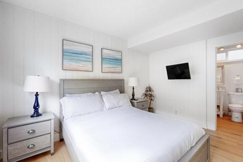 a white bedroom with a bed and a bathroom at Balboa Beauty I in Newport Beach