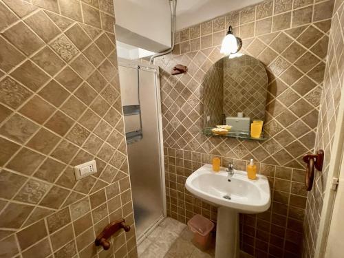 y baño con lavabo y espejo. en Piazzetta San Giovanni B&B, en Specchia