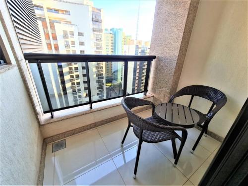 a balcony with two chairs and a table in front of a window at Cullinan 1017E · Hotel Cullinan Luxury Premium com varanda in Brasilia