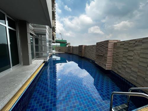 a swimming pool with blue tiles on the side of a building at Cozy Victoria Lakeview 5 mins to Impact Muang Thong in Ban Bang Phang