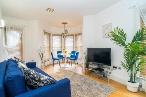 a living room with a blue couch and a tv at Heart of London's West End / Pro Host in London