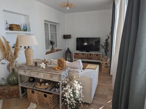 een woonkamer met een bank en een tv bij 2 chambres avec vue panoramique in Montauroux
