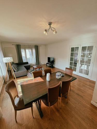 un salon avec une table et des chaises en bois dans l'établissement Duplex avec jardin - Proche Paris - Disneyland - RER -, à Noisy-le-Grand