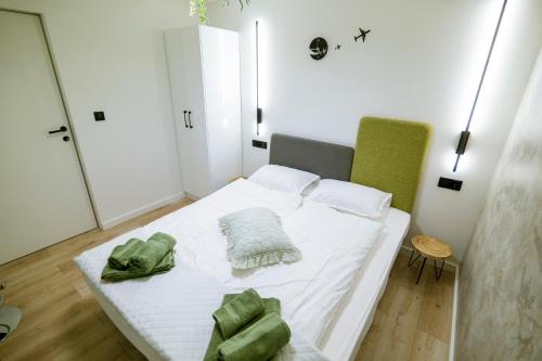a bedroom with a white bed with green towels on it at OdlotLove in Jędrzejów