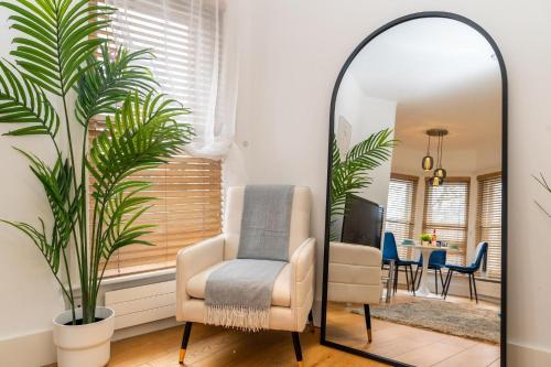 a mirror in a living room with a chair and a table at Heart of London's West End / Pro Host in London