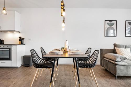 a dining room with a table and chairs and a couch at I Zentral I Modern I Terrasse I in Rüsselsheim