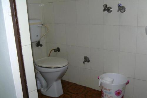 a bathroom with a toilet and a trash can at GRG Hotel Grace Agra in Agra
