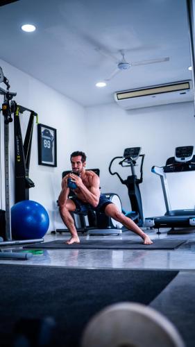 a man sitting on a treadmill in a gym at Garten Hotel in El Zonte