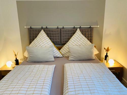 Duas camas com almofadas brancas num quarto em Ferienwohnung Ambiente em Klotten