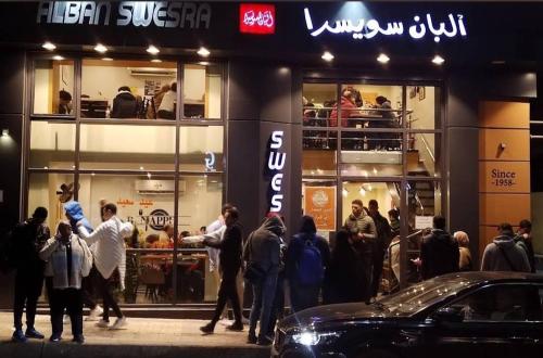 a group of people standing outside of a store at خان العطلات in King Mariout