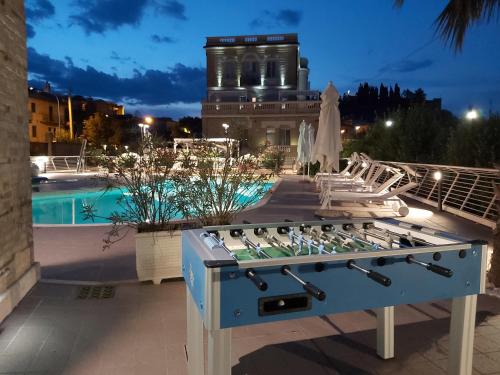 una mesa de mezclas frente a una piscina por la noche en Villa Contessina en Cossignano