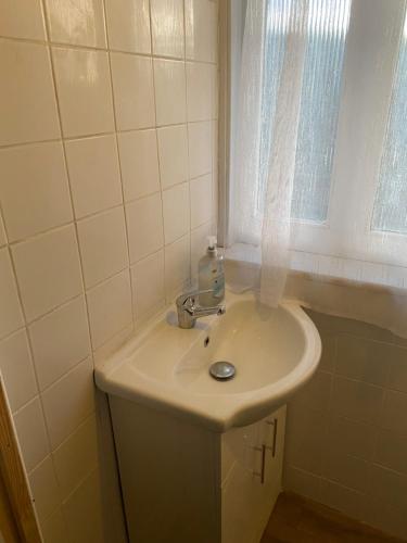 a white sink in a bathroom with a window at Crystal in Crystal Palace